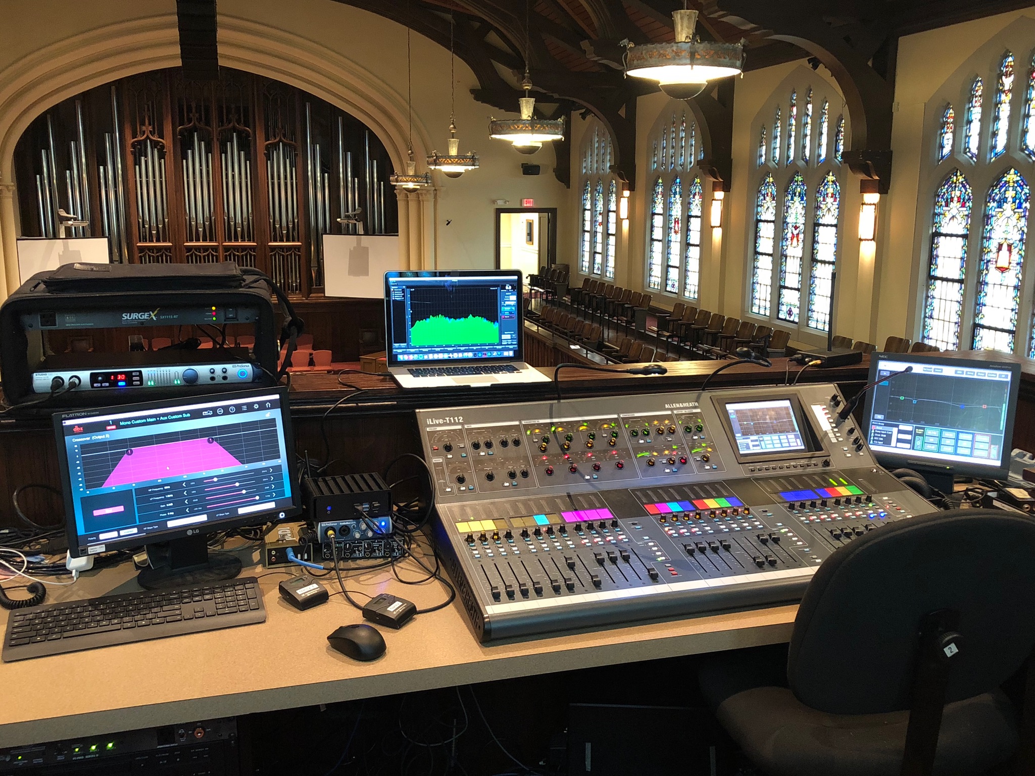 Sunday service at First Presbyterian with the congregation standing, children gathered at the platform, organ pipes and twin screens visible.