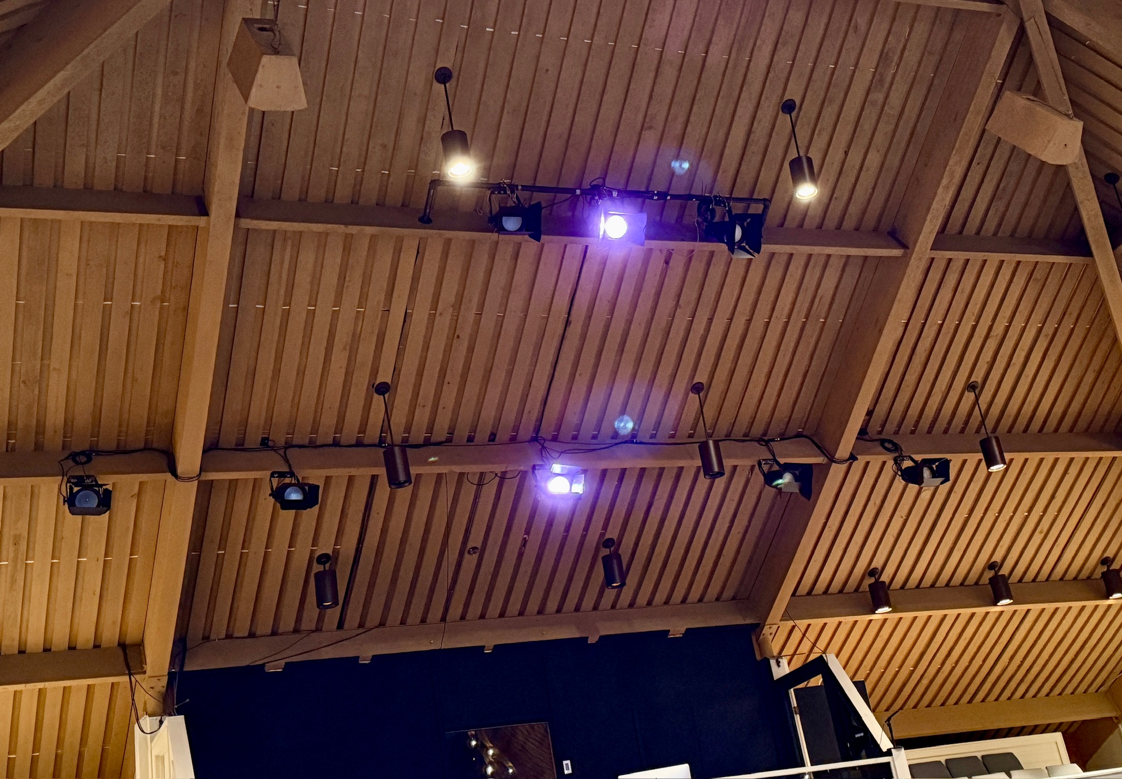 The Chapel on the Campus during a service moment — programmed lighting active across the worship platform, band visible on stage.
