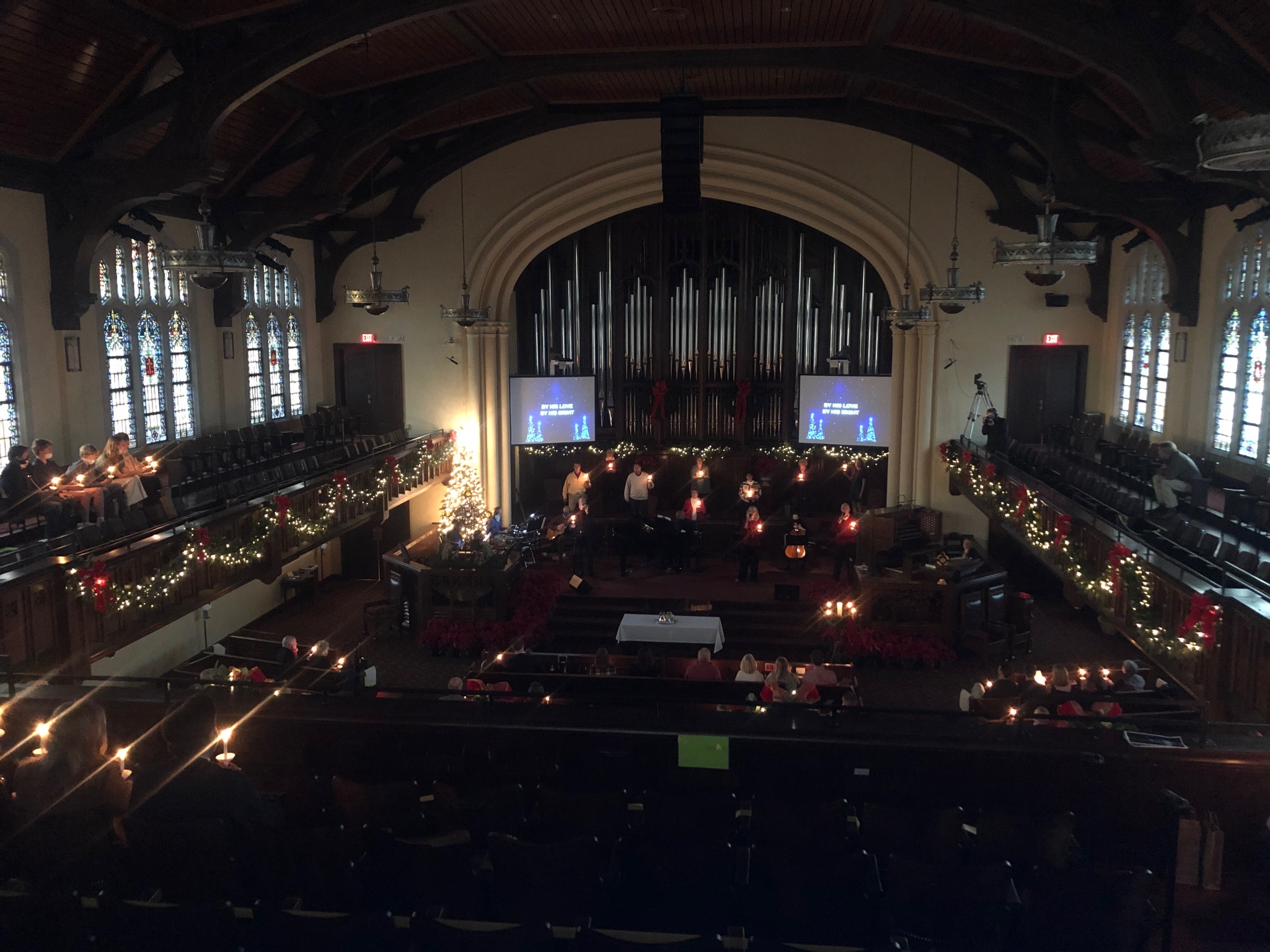 Blaine Wilkins of Pink Palace Media at the FPCBR dLive console during a service, with gothic stained glass arch behind and EXIT signage visible.